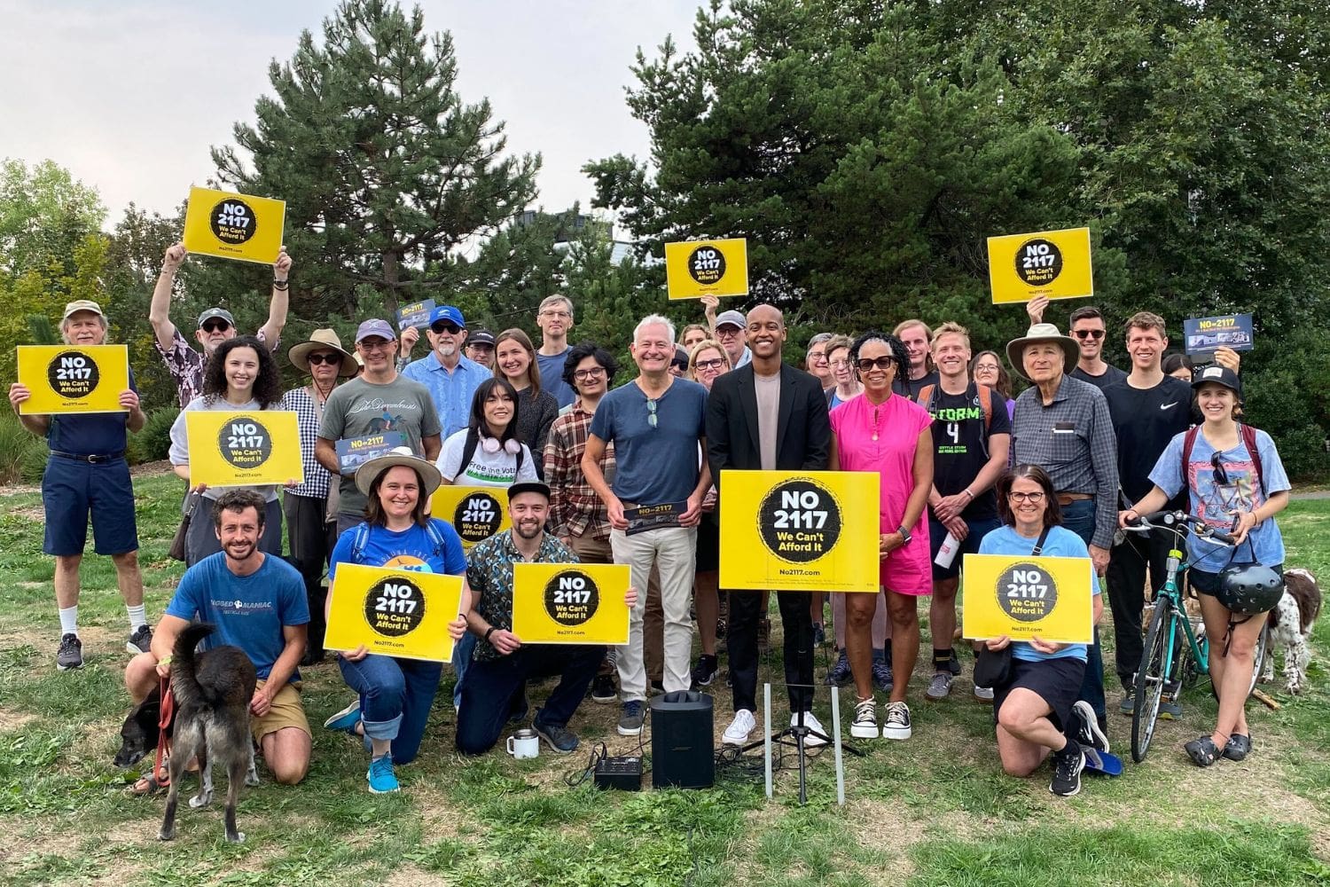 Volunteers gather holding No on 2117 signs.